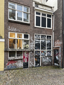 903642 Gezicht op de bekladde achtergevel van het pand Zadelstraat 15 te Utrecht, vanaf het Buurkerkhof.